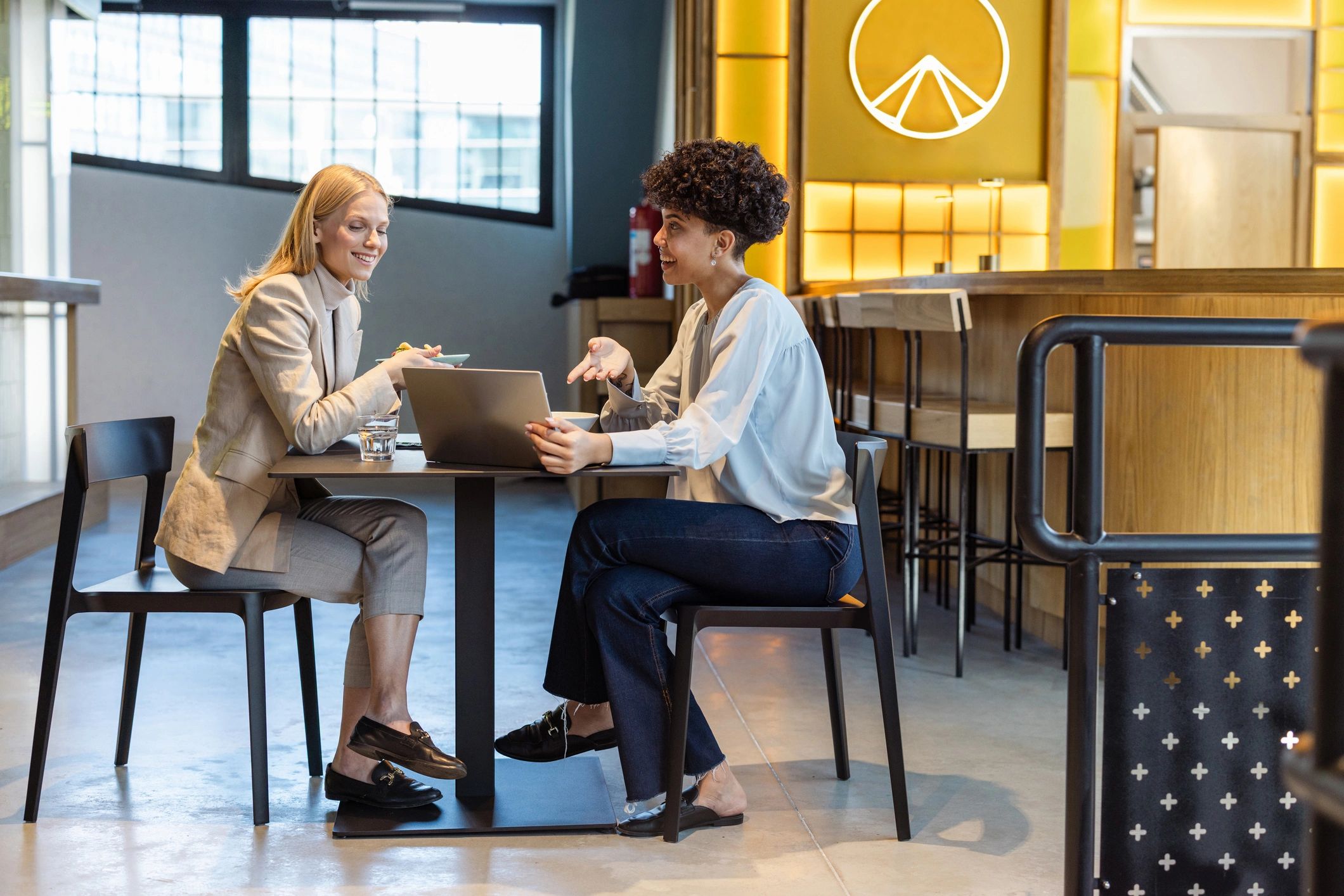 Two professionals discussing options over a laptop